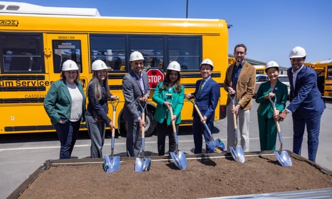 A group of people in business clothes during a ground breaking.