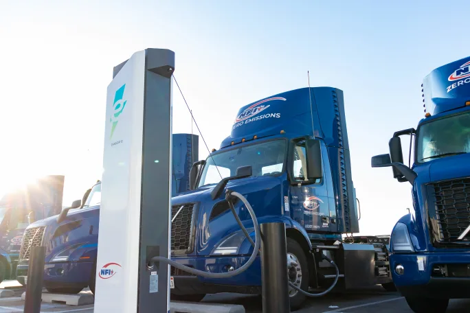 Blue Volvo electric truck at charging station