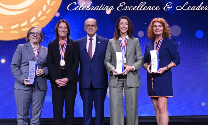 Five public transportation leaders pose with their awards and medals onstage during the 2026 APTA Awards ceremony.