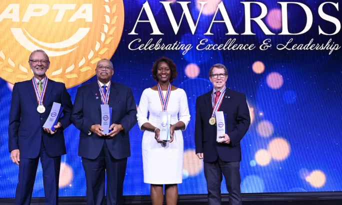 Four APTA Hall of Fame inductees stand together holding awards and wearing medals in front of an APTA Awards backdrop.