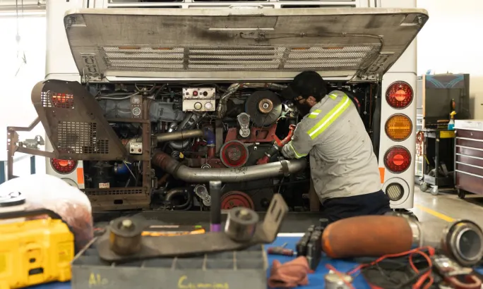 A Valley Metro maintenance technician works inside the rear engine compartment of a bus at the East Valley Bus Operations & Maintenance Facility.