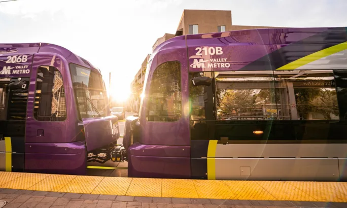 Two connected Valley Metro light rail vehicles at a station platform.
