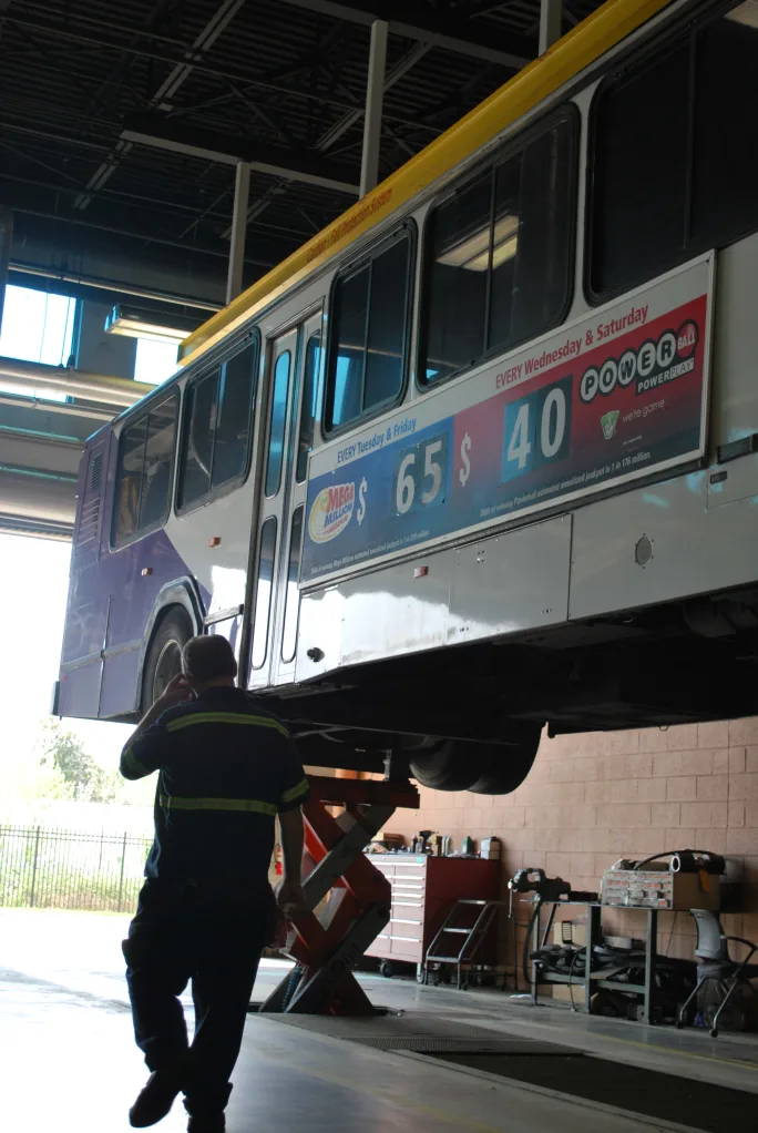 Worker underneath bus
