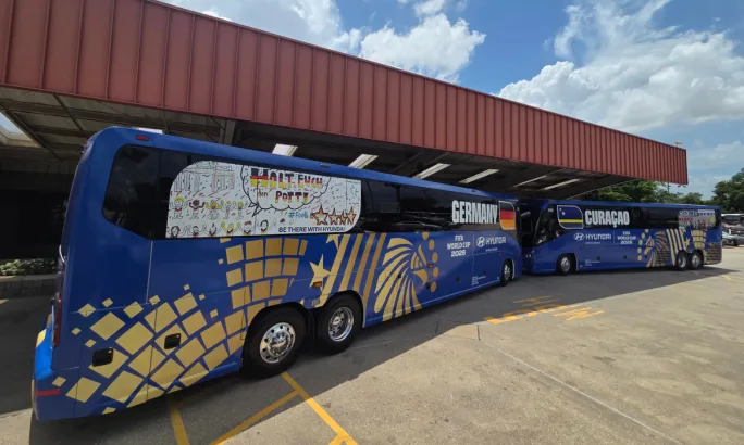 Two First Class Transportation motorcoaches with Germany and Curaçao wraps.