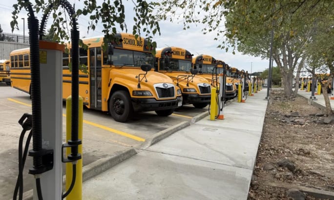A lineup of electric buses near chargers.