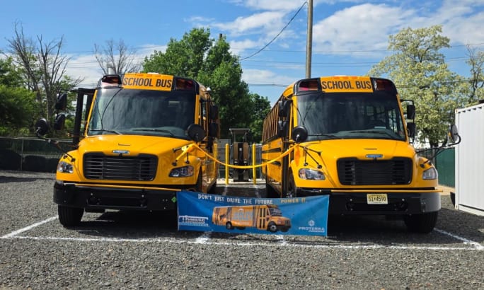 Two Thomas Built Buses Safe-T-Liner C2 Jouley electric school buses parked outside.