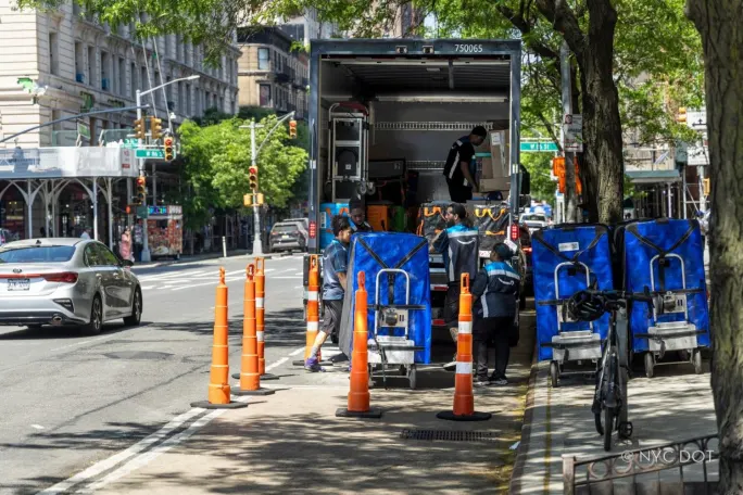 Box truck unloading curbside in a microhub into smaller delivery vehicles