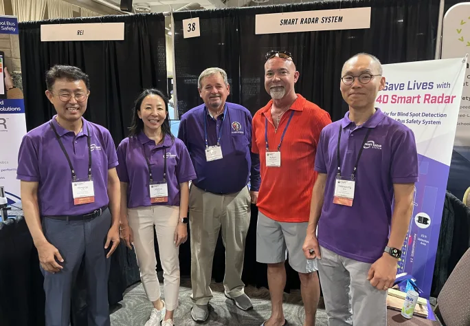 a group of people stand together at a trade show