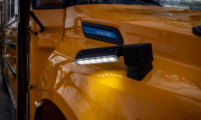 Image of lights attached near the hood of a school bus.