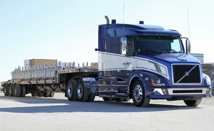 Photo of a Searcy truck pulling an open deck trailer