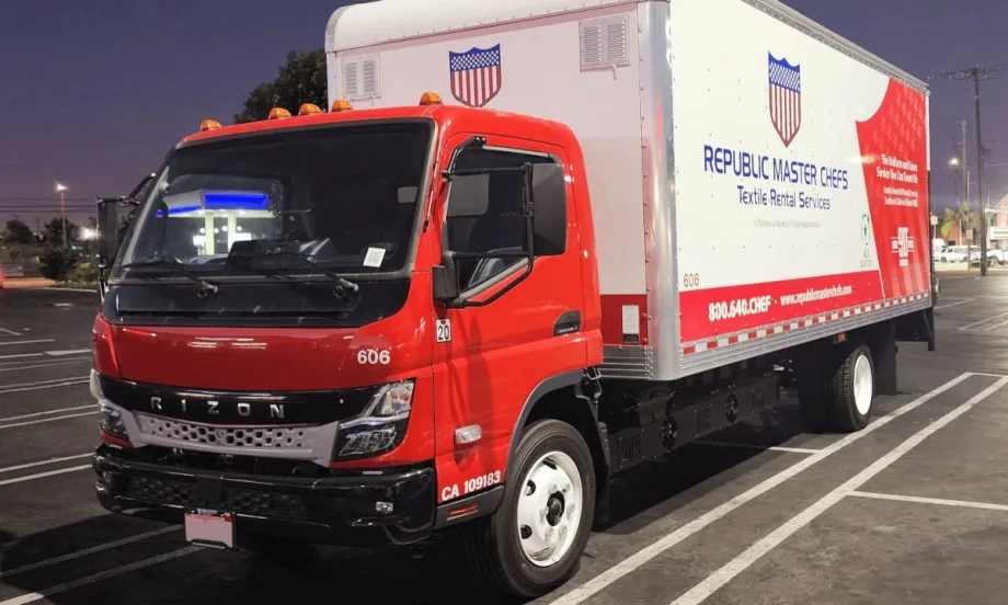 Red Rizon cab-over electric box truck with a Republic Master Chefs-branded cargo box parked in a lot at night.