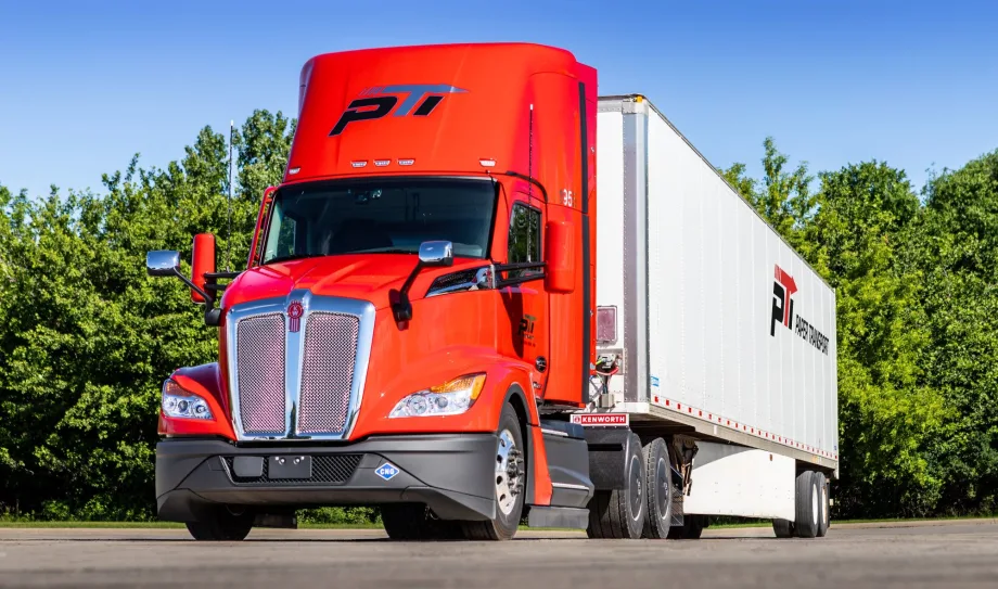 Red Kenworth truck pulling Paper Transport trailer