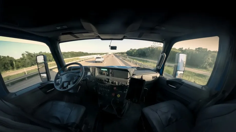 Interior of Class 8 truck cab, with no one in driver or passenger seats, looking out front and side windows from sleeper in a wide angle shot.