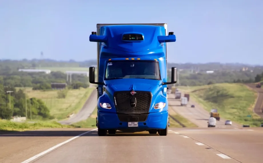 Blue International heavy-duty truck with Aurora driverless truck software coming head-on on an interstate highway