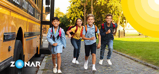 Image of happy school children exiting their school bus