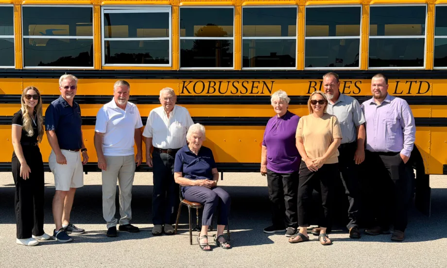 Multiple generations of the Kobussen family posing in front of a school bus.