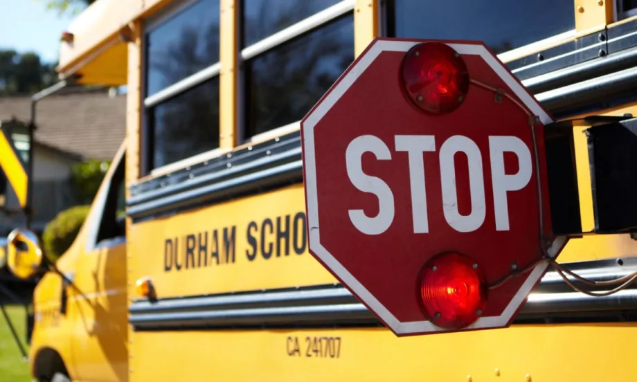 A Durham School Services bus with its stop arm extended.