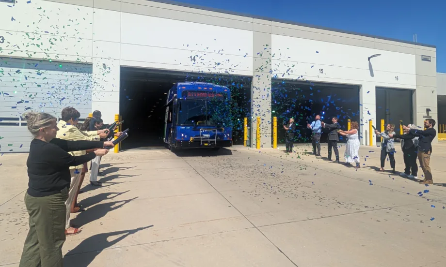 A group of people with confetti cannons and a Pace transit bus.