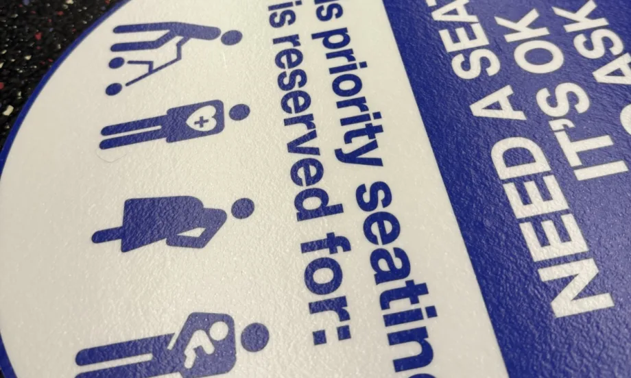 An up close image of WMATA priority seating sticker reminders.