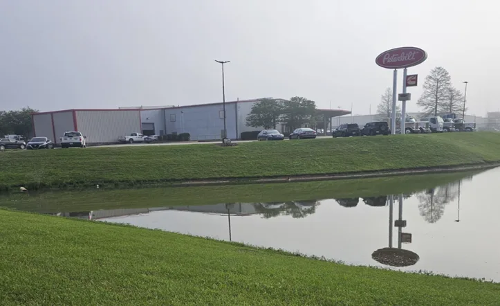 Photo of truck dealership with pond in foreground