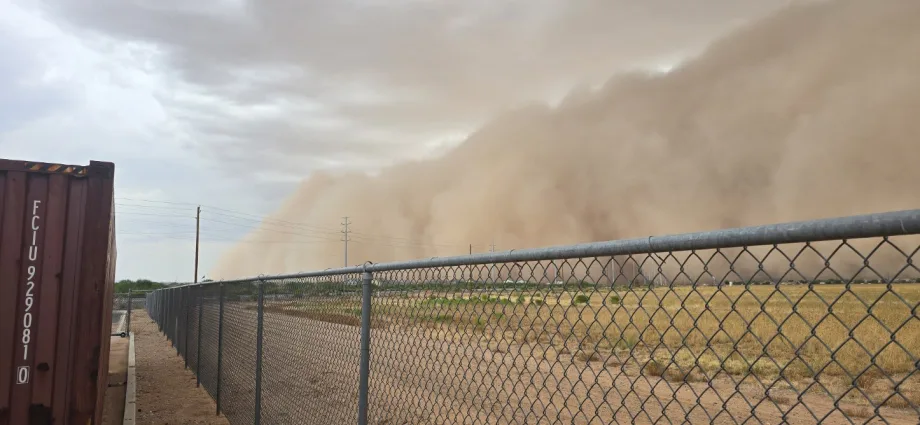 Large monsoon dust and rain wall moving across a field in Pinal County, Arizona, as severe weather brought flash flooding and hazardous driving conditions during school transportation operations.
