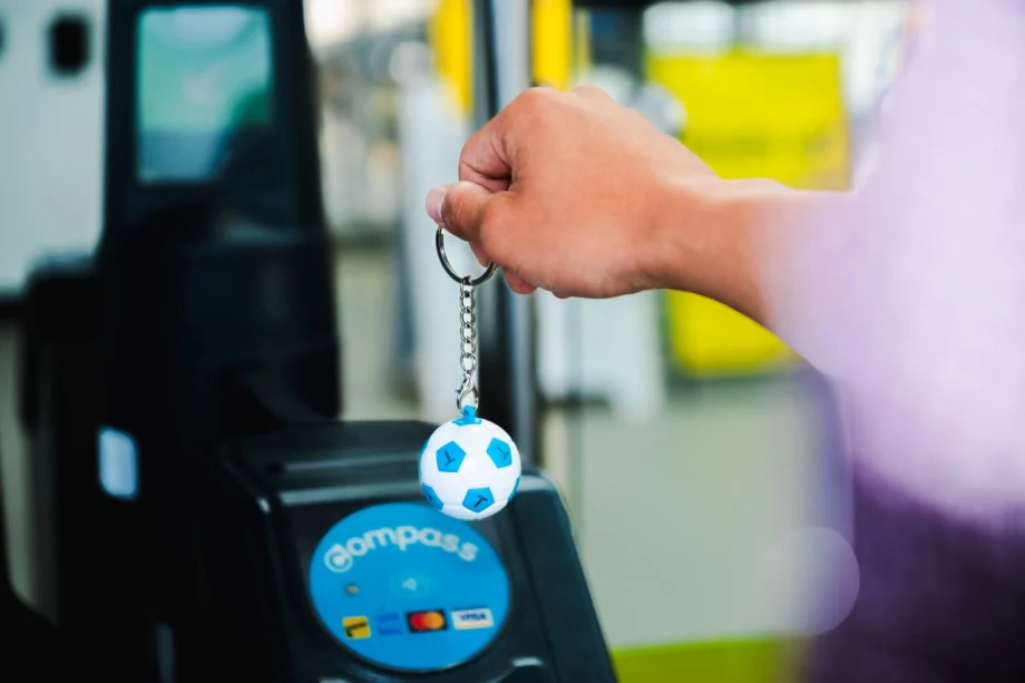 A person holding up a TransLink Compass Soccer Mini to a navigation terminal.