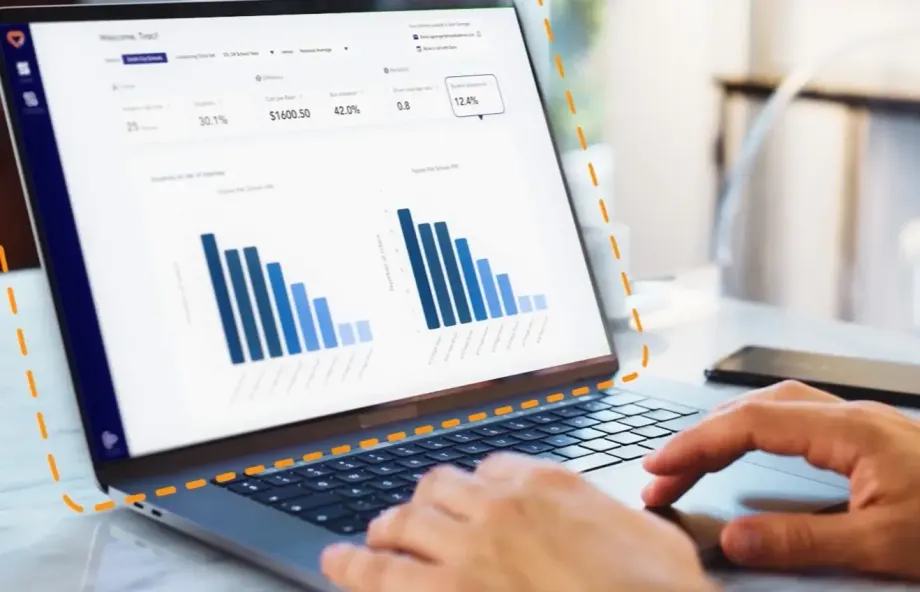 Laptop displaying HopSkipDrive RouteWise AI transportation analytics dashboard with charts and routing performance data for school district operations.
