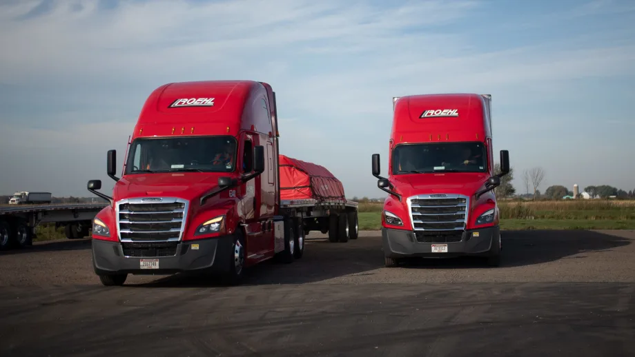 Two red heavy-duty Class 8 trucks with Roehl branding